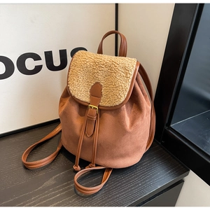 Detail of suede and sherpa stitching on a brown backpack with vintage metal buckle