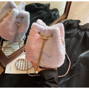 Detail of plush bucket bag with pink gradient fur, star sequins and pearl drawstring charm