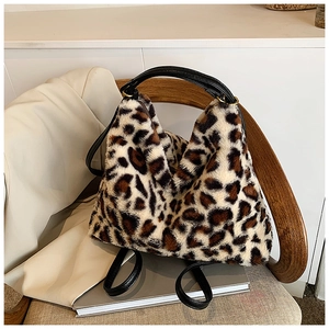 Gros plan d'un sac cabas en fausse fourrure léopard avec anses noires sur une chaise
