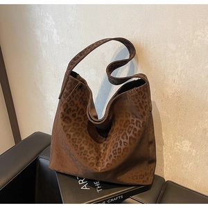 Detail shot of leopard print hobo bag texture on artistic book backdrop with high-end vibes