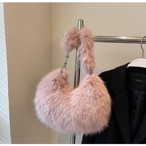 Gros plan détaillé du sac en fausse fourrure rose avec pendentif coeur en métal