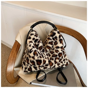 Détail du sac cabas en fausse fourrure léopard avec poignées en cuir sur chaise design