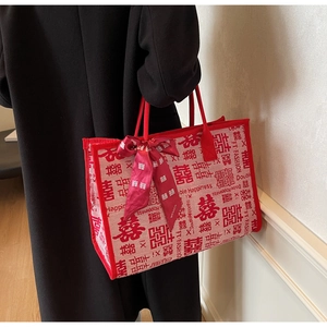 Detail of red wedding tote bag featuring Double Happiness patterns and silk bow ribbon