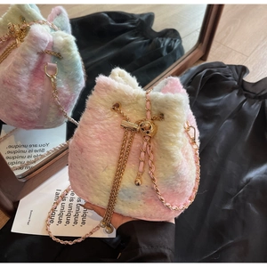 Detail of rainbow plush bucket bag with golden chain strap and sparkling pastel fur