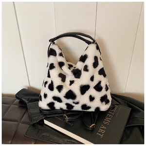 Détail du sac cabas en fausse fourrure blanche à motifs de cœurs noirs et boucles dorées