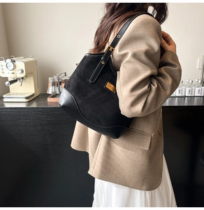 Detail der schwarzen Schultertasche aus Wildleder und Leder mit verstellbarer Gold-Schnalle