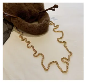 Detail of plush brown bucket bag showing the soft faux fur texture and gold chain strap