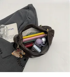 Macro shot showing large interior capacity of brown leather hobo bag with daily essentials