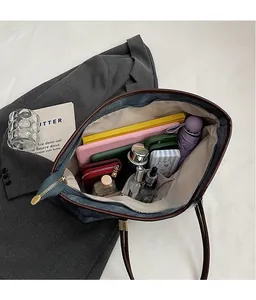 Spacious interior of denim tote bag showing laptop, umbrella and cosmetic storage
