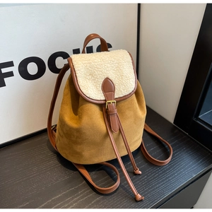 Detail of suede bucket backpack with plush fleece trim and brown leather drawstring closure