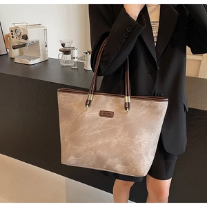 Detail of grey marble pattern tote bag with brown leather handles and Fashion logo
