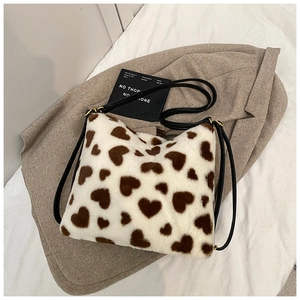 Détail du sac à épaule en peluche blanche avec motifs de cœurs bruns en fausse fourrure