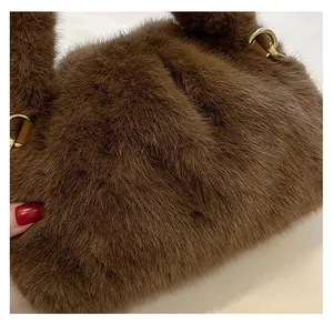Detailed view of brown faux fur handbag with leather handle attachment and gold metal ring