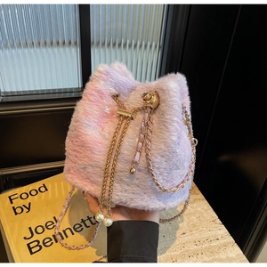 Detail of plush bucket bag with pink gradient faux fur and gold chain strap with pearls