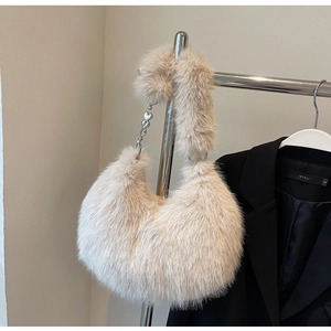 Détail du sac à main en peluche beige avec breloque cœur et texture douce