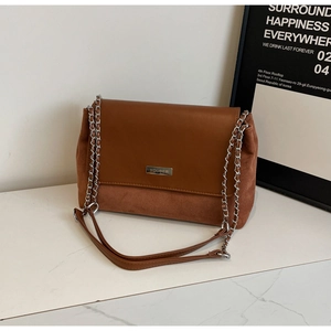 Details der braunen Vintage-Schultertasche mit Wildledertextur und Logo-Metallplatte