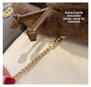 Detail of the detachable gold metal chain strap and hook on the brown faux fur handbag