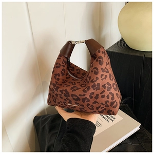 Detail der hobo-tasche mit leopardenmuster, dunkelbraunem ledergriff und metallverschluss