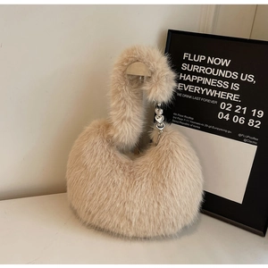 Vue détaillée du sac à main en fausse fourrure beige avec pendentifs cœur en métal