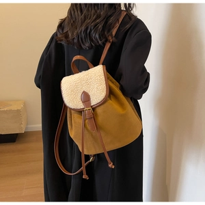 Detail of yellow canvas backpack with cream sherpa flap and brown leather straps