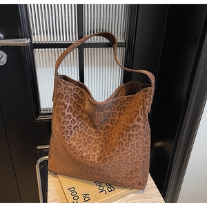 Detail view of stylish leopard print tote bag with soft suede texture and wide strap