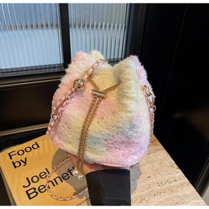 Detail of plush gradient bucket bag with gold chain strap and pearl charm accent