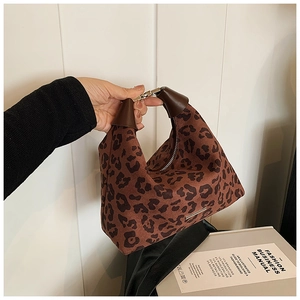 Detail einer braunen Hobo-Tasche mit Leopardenmuster, Wildleder-Textur und Silberbeschlägen