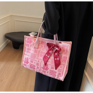 Detailed shot of a pink bridal tote bag with red Double Happiness prints and ribbon