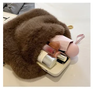 Furry brown crossbody bag showing spacious interior with phone, umbrella and makeup items
