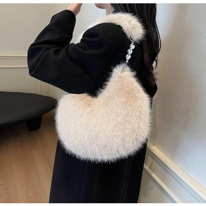 Détail d'un sac en fausse fourrure beige en forme de cœur avec chaîne argentée