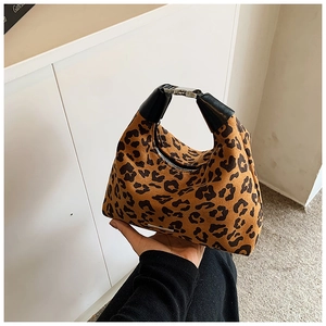 Detailansicht der Handtasche mit Leopardenmuster, Druckknopf und schwarzem Lederriemen