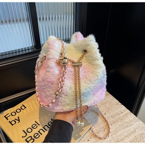 Detail of plush bucket bag with golden chain, drawstring closure and pearl charm