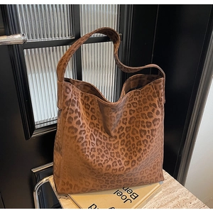 Detail of the brown leopard print tote bag with wide strap on a stone surface