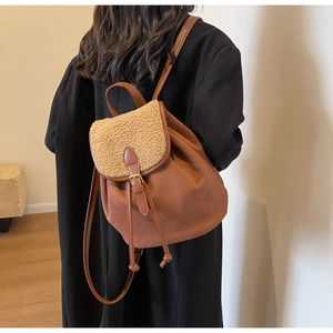 Detail of vintage brown backpack with khaki faux fur flap and slim leather straps