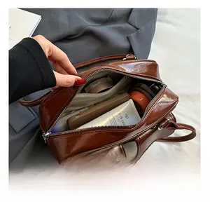 Vue intérieure du sac en cuir marron montrant une grande capacité pour cosmétiques et mobile