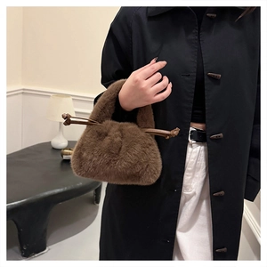 Detail of soft dark brown plush faux fur bucket bag with drawstring closure and texture