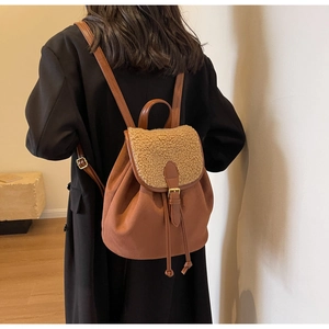 Detail of brown faux suede backpack with sherpa fleece flap and drawstring closure