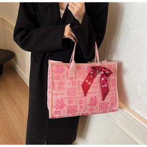 Detailed close-up of pink canvas tote bag with Double Happiness print and red ribbon bow