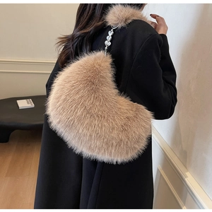 Détail d'un sac à bandoulière en peluche en forme de cœur avec chaîne en métal argent