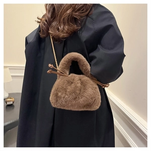 Detail of brown faux fur bucket bag featuring gold chain and soft texture