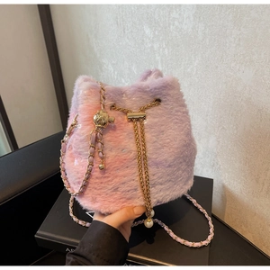 Close-up of plush faux fur bucket bag with golden chain and pearl drawstring details