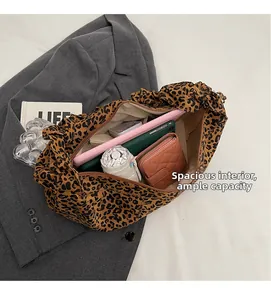 Vue détaillée de l'intérieur spacieux du sac léopard contenant des objets du quotidien