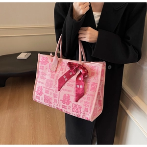 Detail of pink bridal tote bag with double happiness print and red silk ribbon bow decoration
