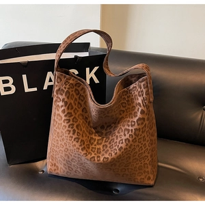 Detailed view of the leopard print faux fur texture and wide strap on the large tote bag