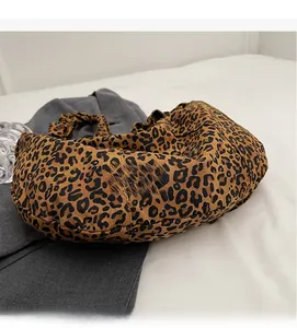 Détail du tissu doux à motif léopard et de la texture spacieuse de ce sac bandoulière