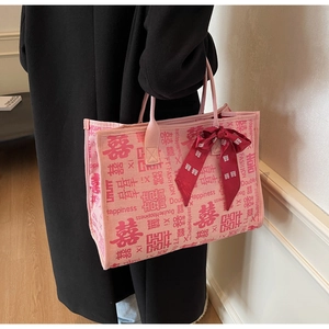 Detail of pink wedding tote bag with Double Happiness print and red ribbon bow