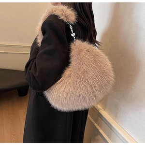 Détail du sac à main en fausse fourrure en forme de cœur avec bandoulière à chaîne