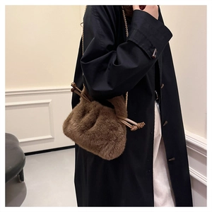 Detail of plush brown bucket bag with gold chain strap and drawstring leather trim