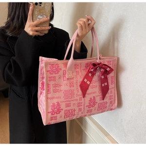 Detail of a pink wedding tote bag featuring Double Happiness prints and red silk bow