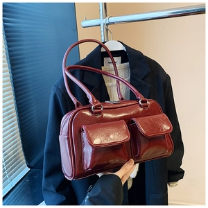 Détail du sac à main rouge foncé brillant avec double poche à rabat sur le devant